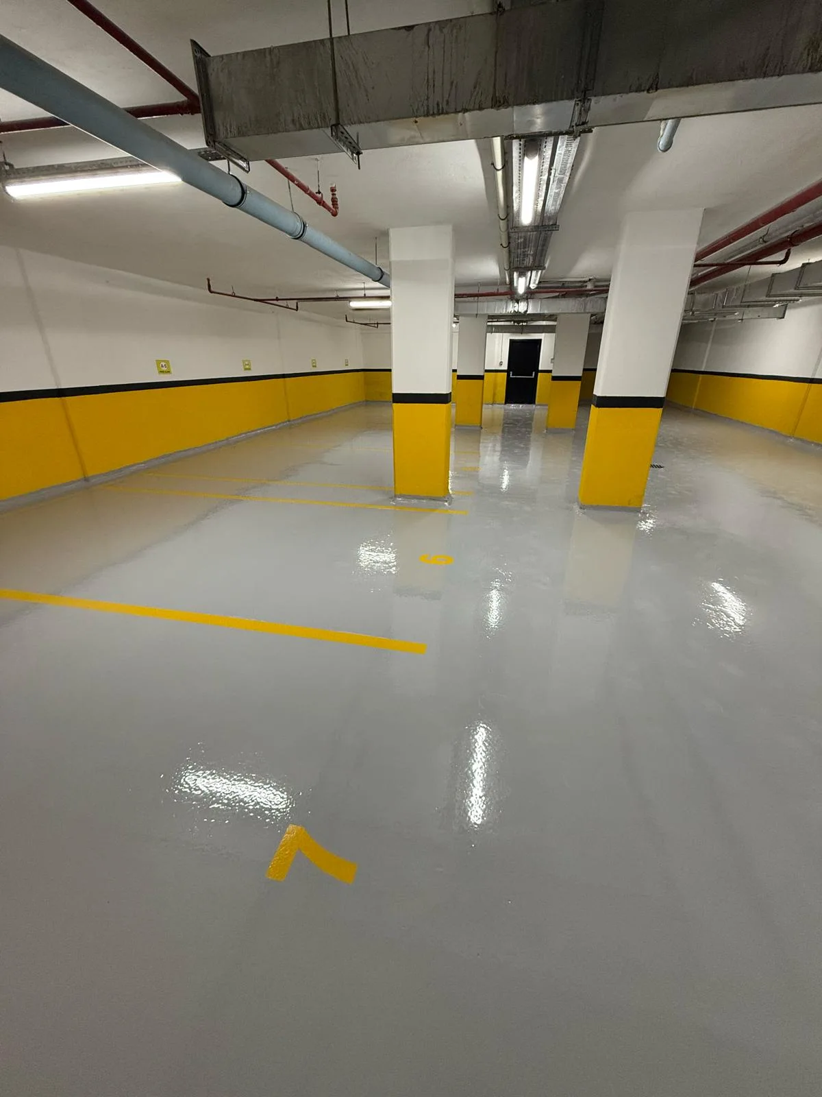Kapalı otoparkta sarı işaretlemeli gri zemin – Otopark epoksi zemin kaplama saha fotoğrafı